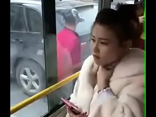 Ragazza cinese baciata. Beside autobus.